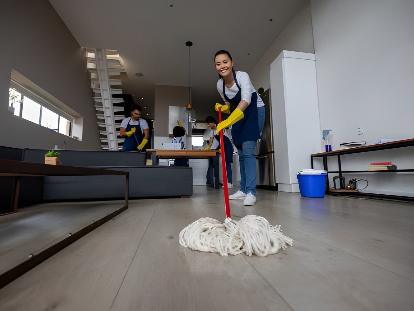 Woman mops the floor in a modern living room
